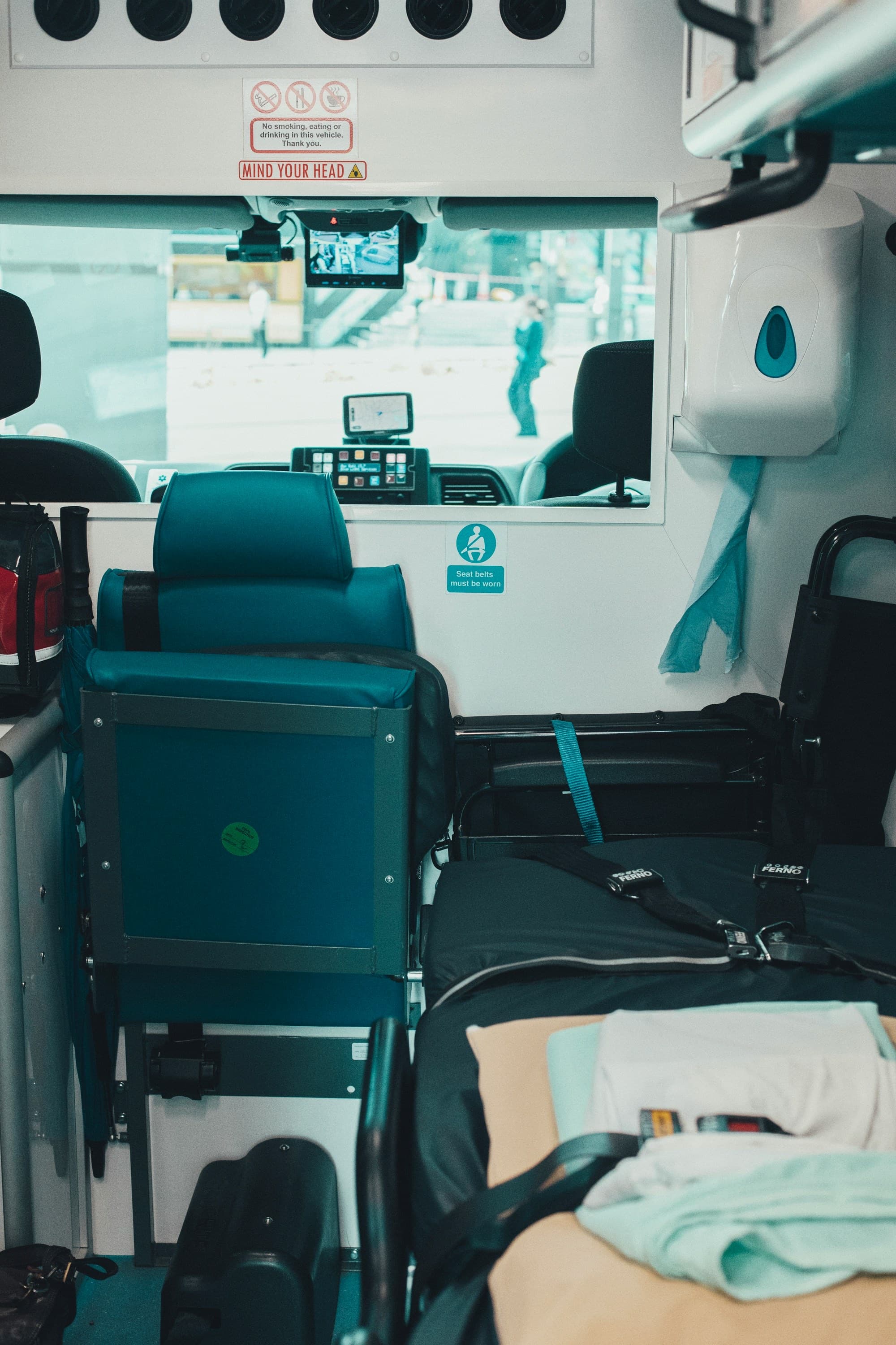 The interior of a medical transport vehicle, showing a clean patient seating area and equipment storage